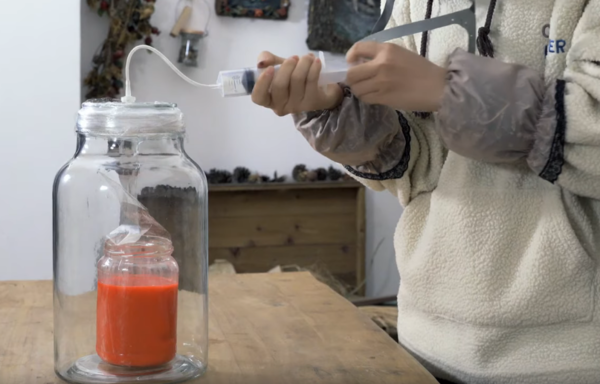 A simple vacuum chamber using a glass bottle and plastic syringe.
